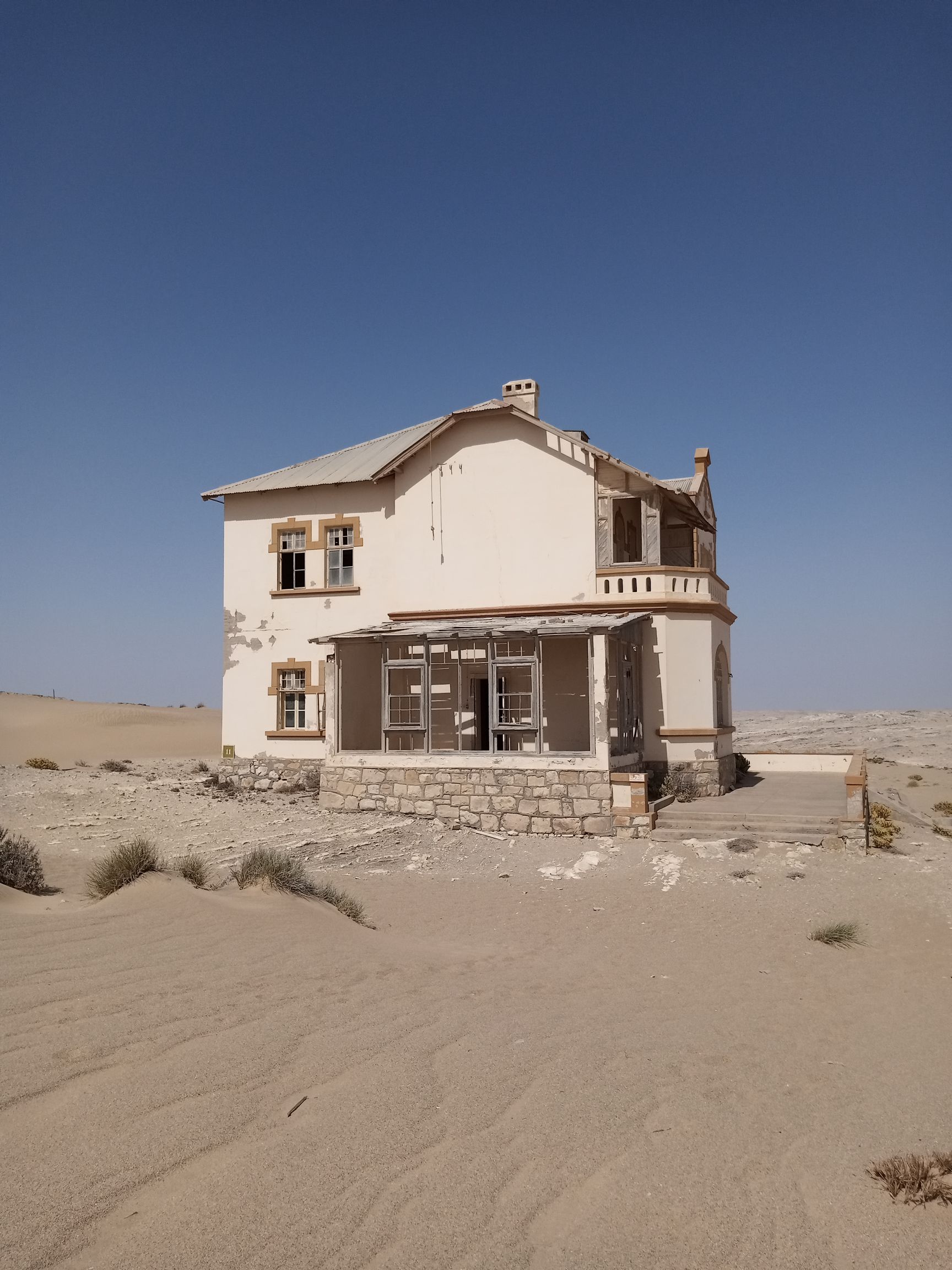Kolmanskop ballroom with chandelier and sand dunes Namibia
